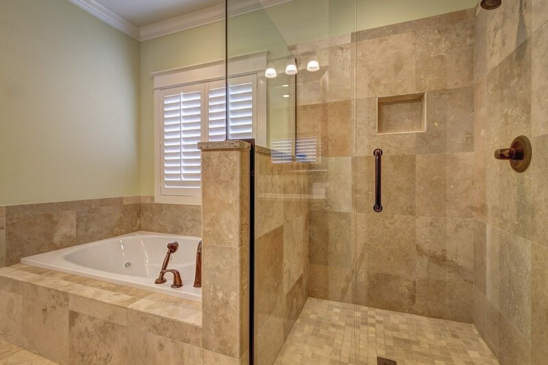 travertine-tiled-shower-beside-built-in-bathtub
